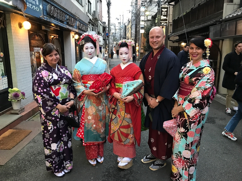 Groupe de personnes portant des kimonos japonais traditionnels dans un cadre de rue.