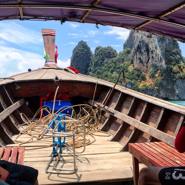 Vue depuis un bateau en bois sur des formations calcaires.