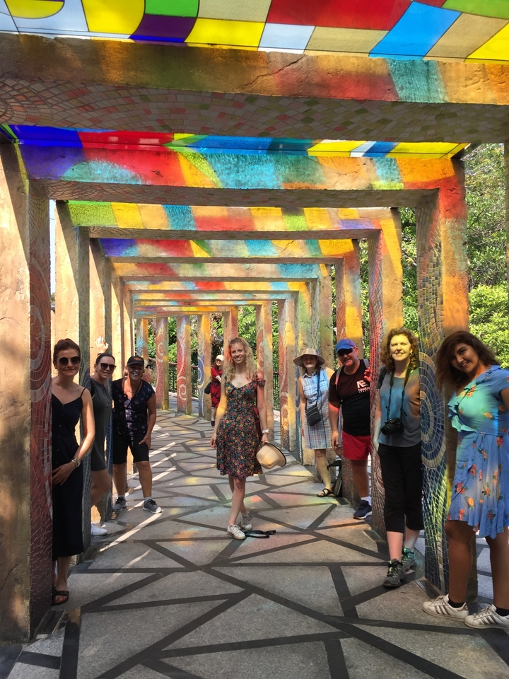 Groupe marchant dans un tunnel coloré avec des motifs culturels.