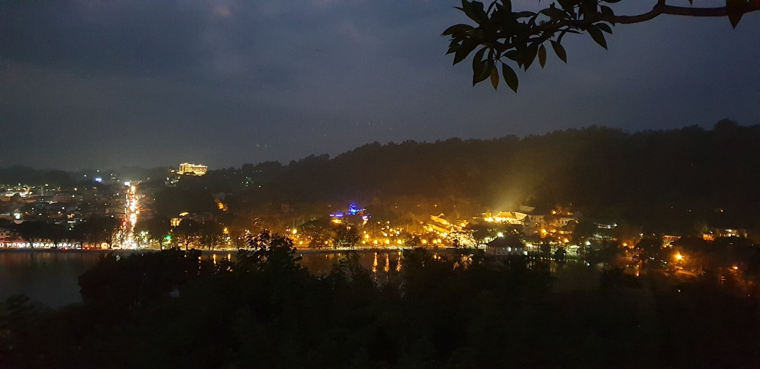 Vue nocturne d'une ville avec des lumières vue de loin.
