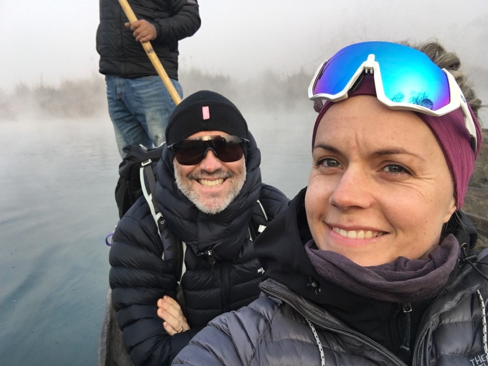 Des gens qui sourient sur un bateau dans une eau brumeuse.