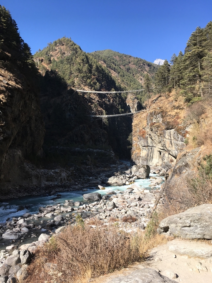 Paysage rocheux avec une rivière et des ponts suspendus.