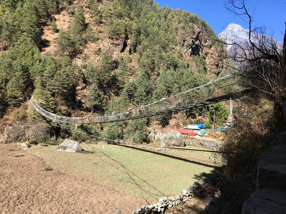 Groupe de randonneurs faisant du trekking près de ponts et de montagnes.