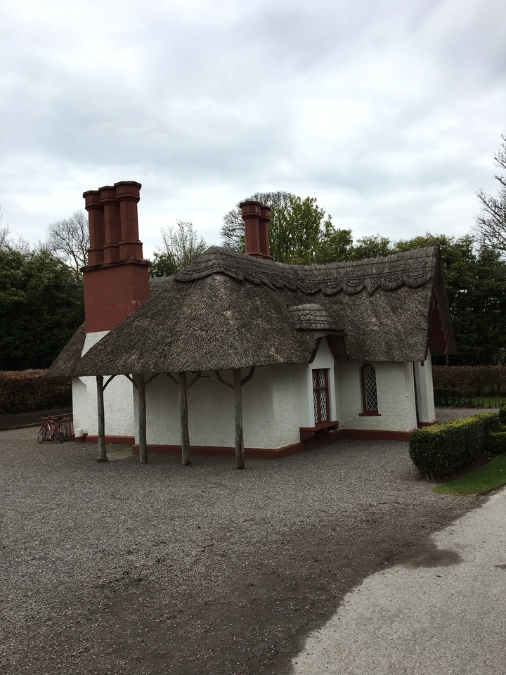 Petit chalet au toit de chaume dans un cadre de parc.