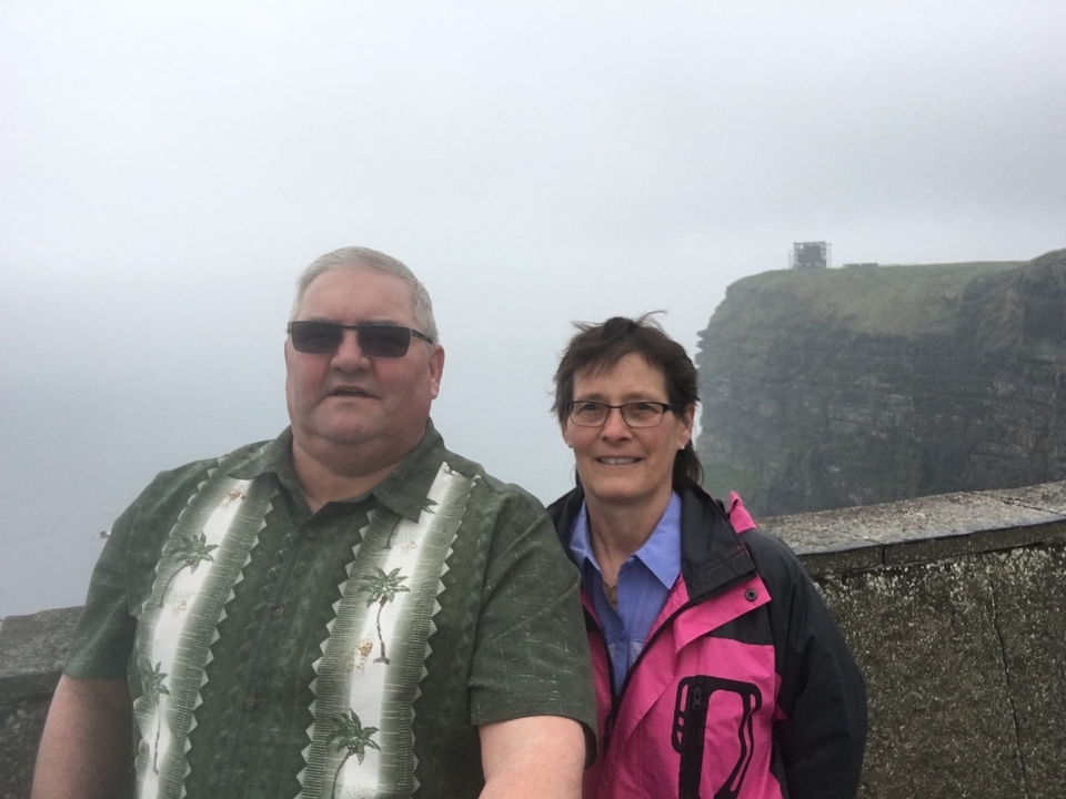 Selfie avec un couple aux falaises de Moher par temps nuageux.