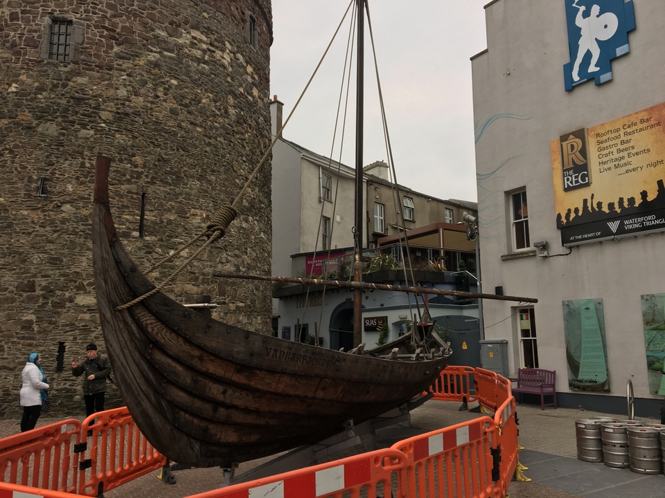 Bateau en bois exposé dans un cadre urbain moderne.