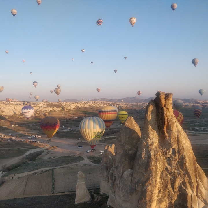 De nombreuses montgolfières au-dessus d'un paysage rocheux.