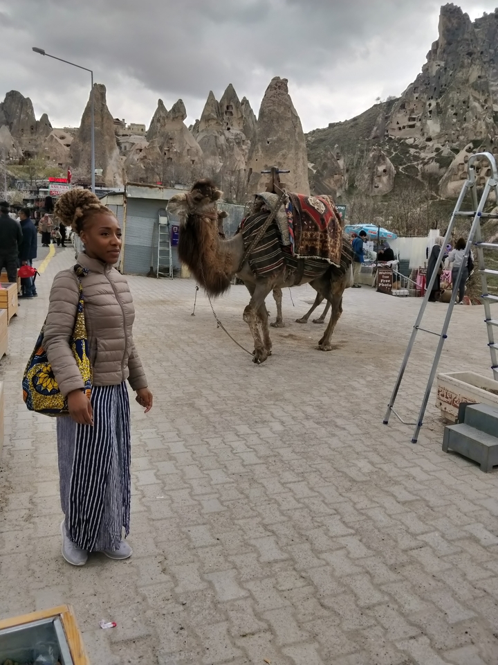 Une personne debout près d'un chameau.