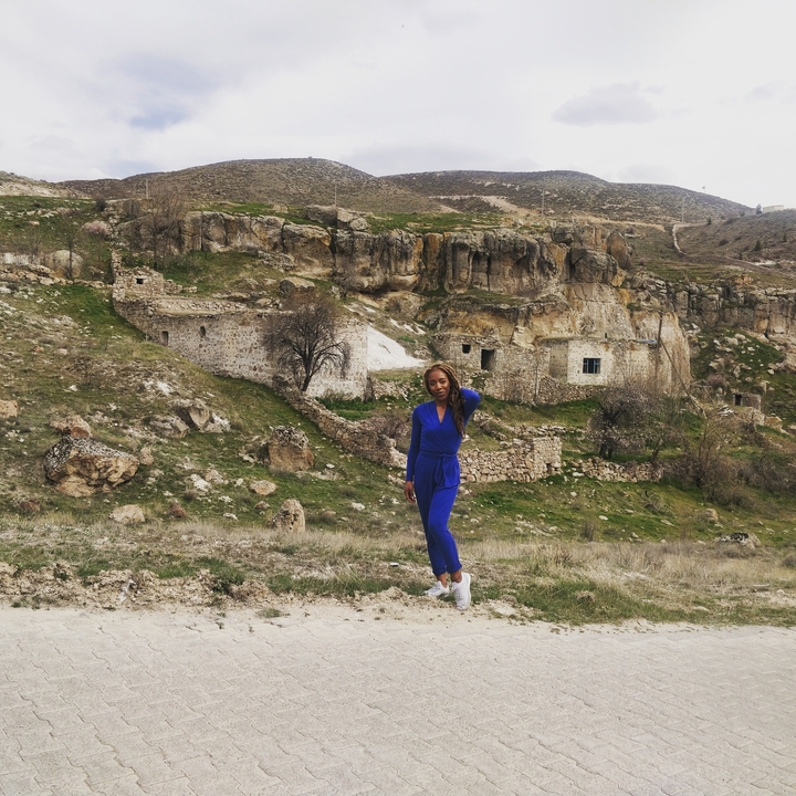 Personne posant devant des formations rocheuses.