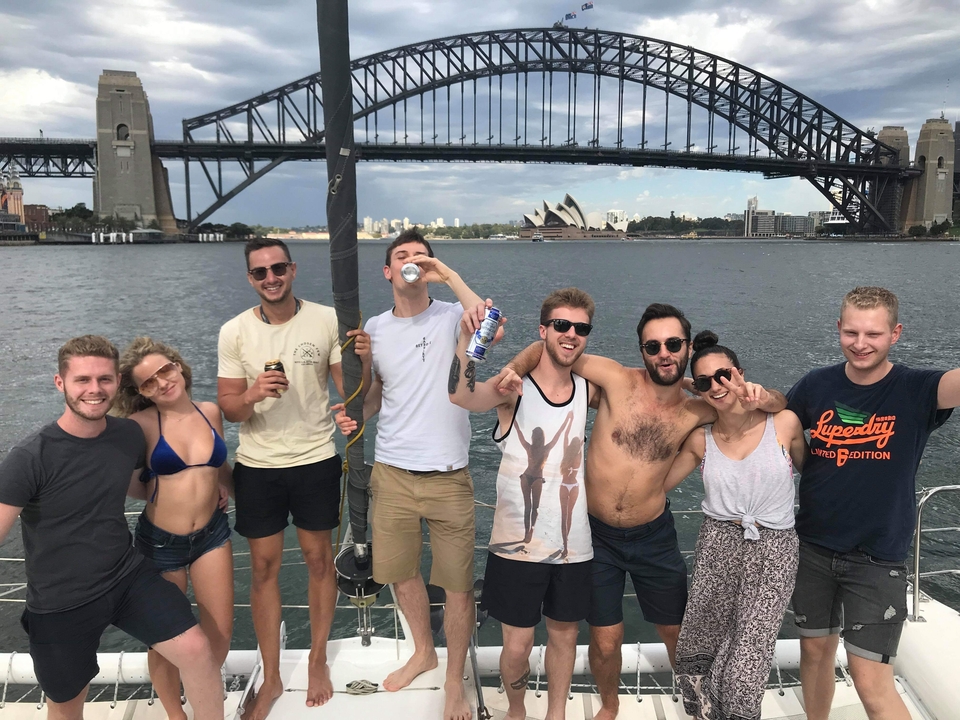 Group posing happily with Sydney Opera House and Harbour Bridge in the background.