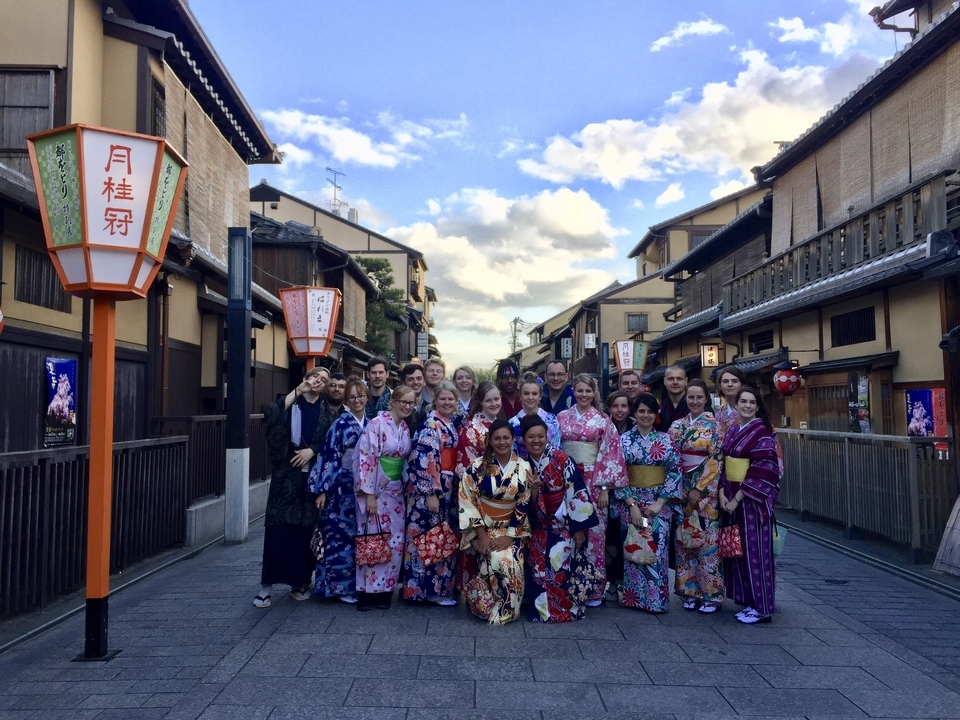 Grand groupe de personnes portant des vêtements traditionnels japonais dans une rue historique.