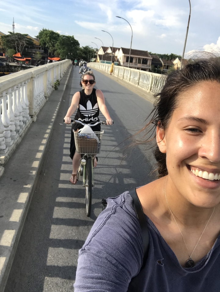 Deux femmes à vélo souriant à la caméra, capturant le moment.