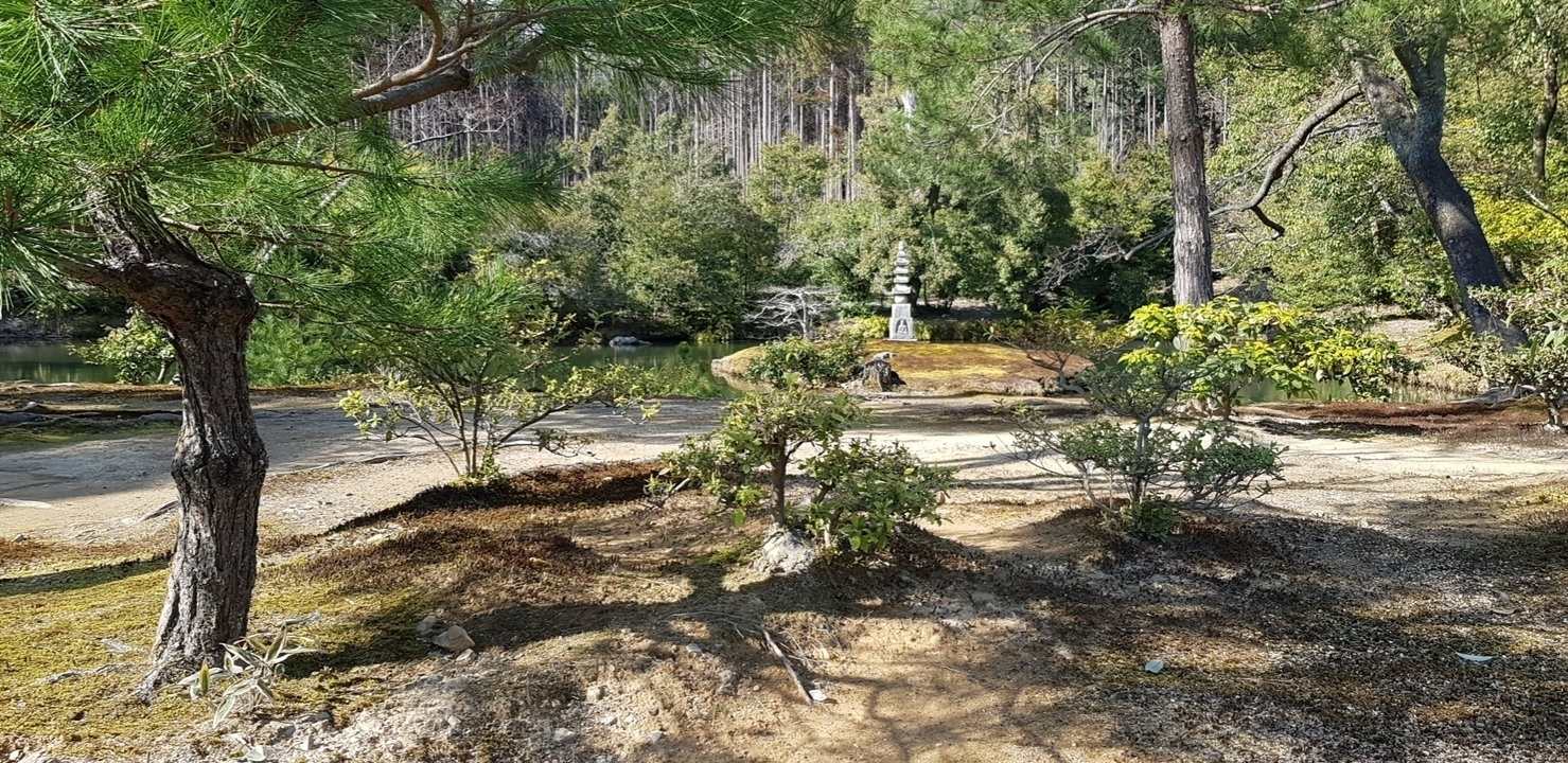 Jardin paisible avec une petite structure en pierre et des arbres.