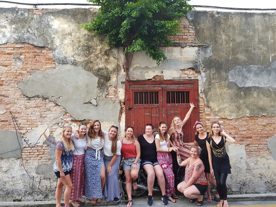 Groupe posant contre un mur de briques vieillies.