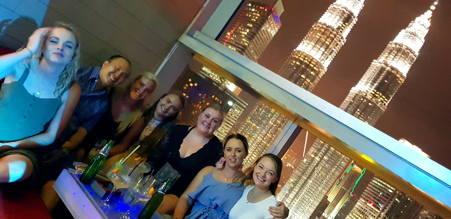 Groupe la nuit avec des tours illuminées en arrière-plan.