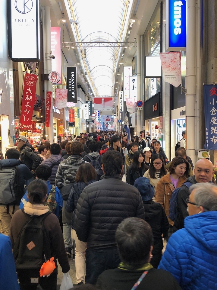 Rue commerçante bondée de monde.