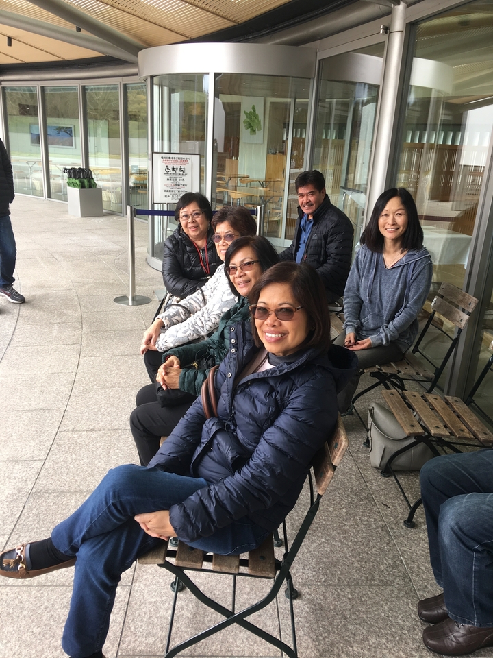 Groupe assis sur des bancs à l'extérieur.