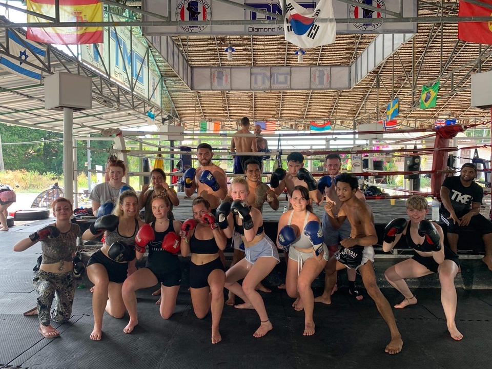 Group boxing training in a gym with gloves.