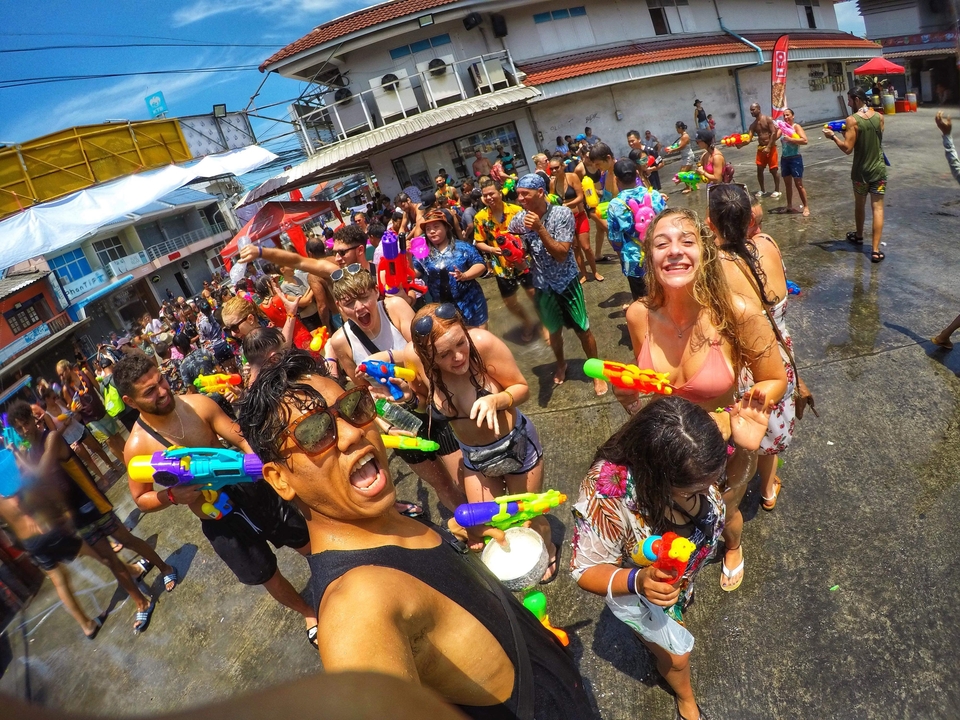 People enjoying a water festival with water guns.