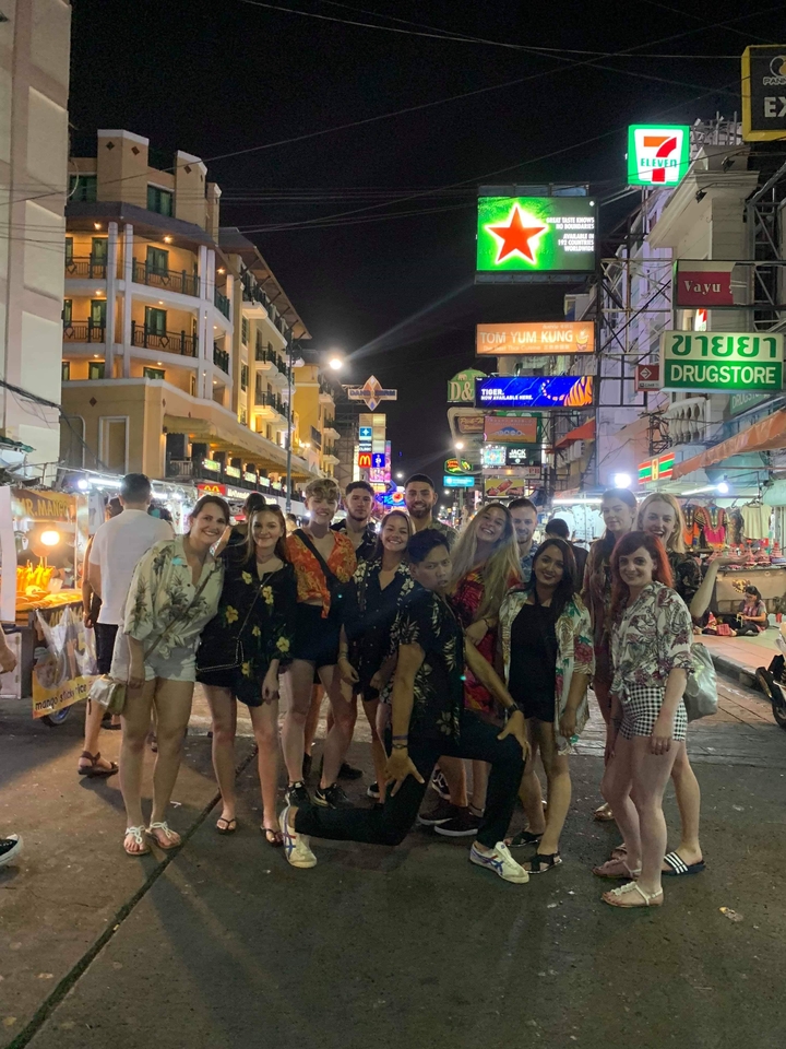 Group of friends on a lively street at night.