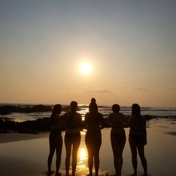 Des gens en silhouette contre un coucher de soleil sur une plage.