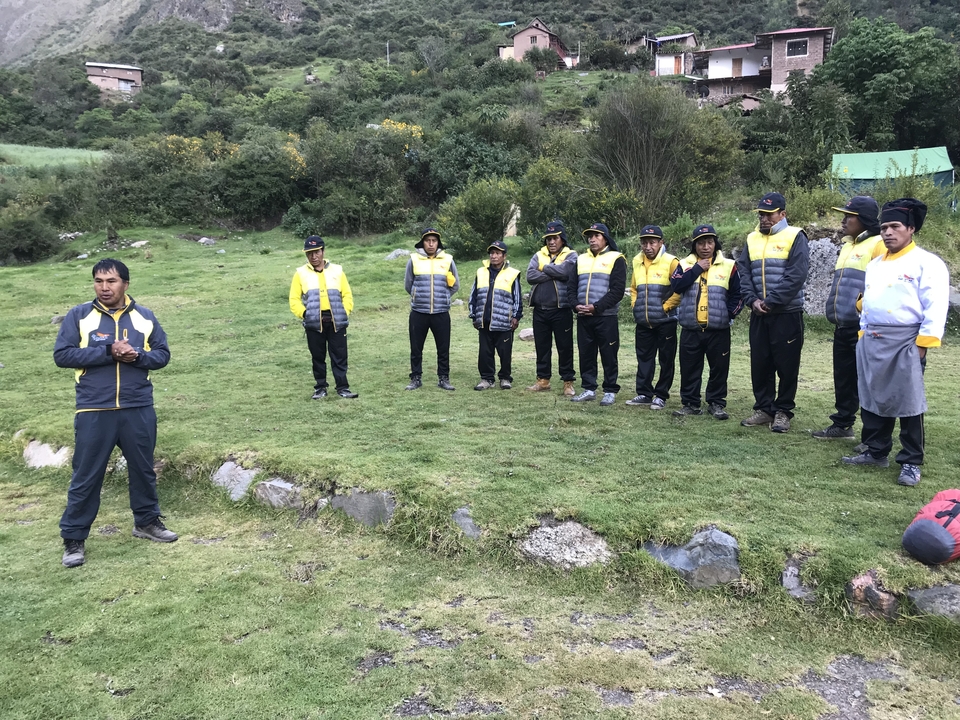 Un groupe de personnes debout sur l'herbe, certaines portant des uniformes.