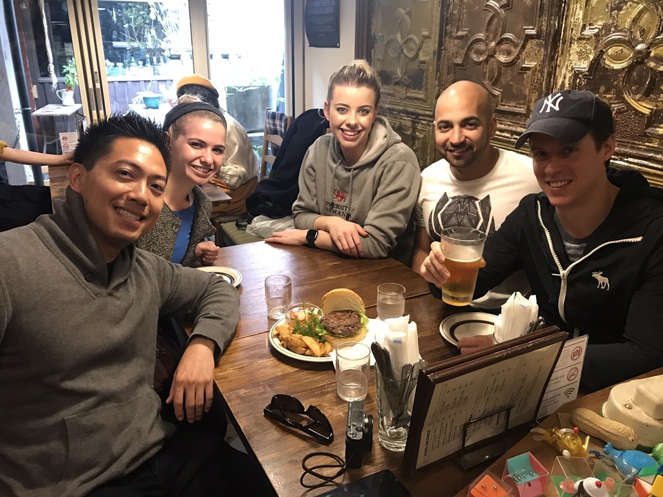 Groupe de personnes à une table avec des hamburgers et des boissons.