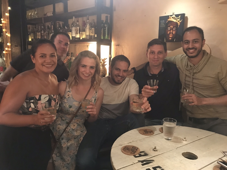 Cinq personnes savourant des boissons dans un bar chaleureux.