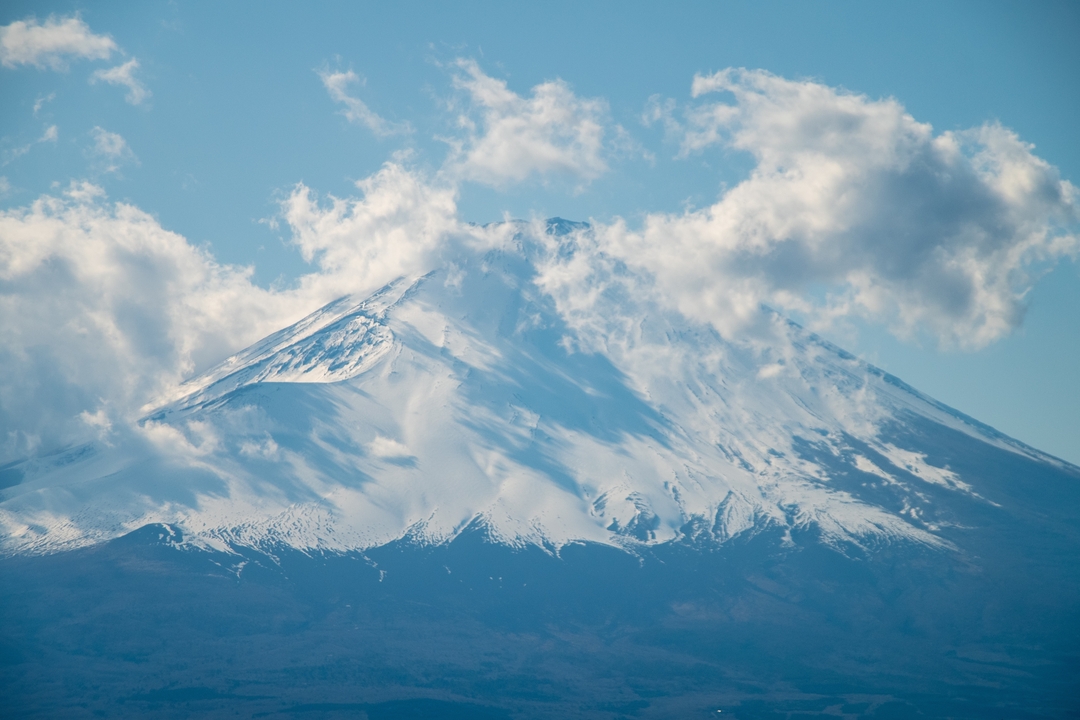 Sommet de montagne enneigé avec des nuages.