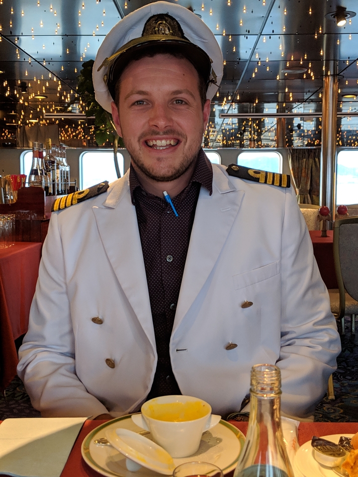 Personne en veste blanche avec insignes de capitaine debout à l'intérieur.