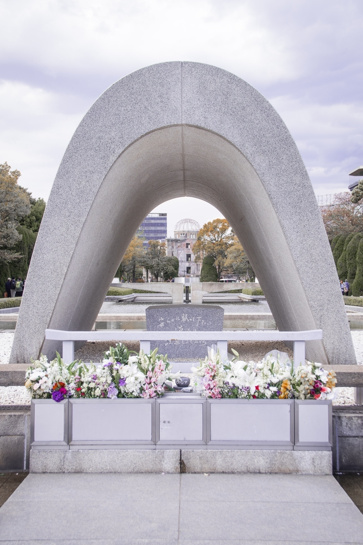 Monument commémoratif avec des fleurs dans un parc.