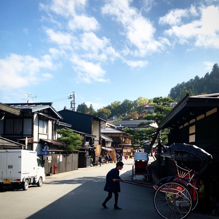 Scène de rue charmante au Japon avec des bâtiments traditionnels et des gens.