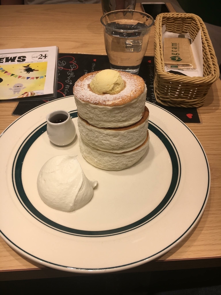 Pile de crêpes moelleuses avec crème et sirop dans une assiette.