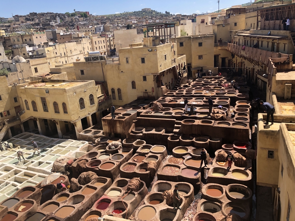 Vue d'ensemble d'une tannerie traditionnelle avec des cuves colorées.