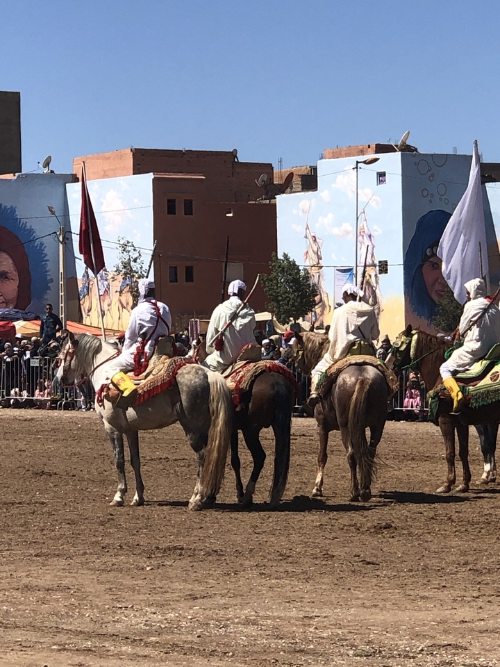 Cortège festif à cheval avec des tenues colorées.