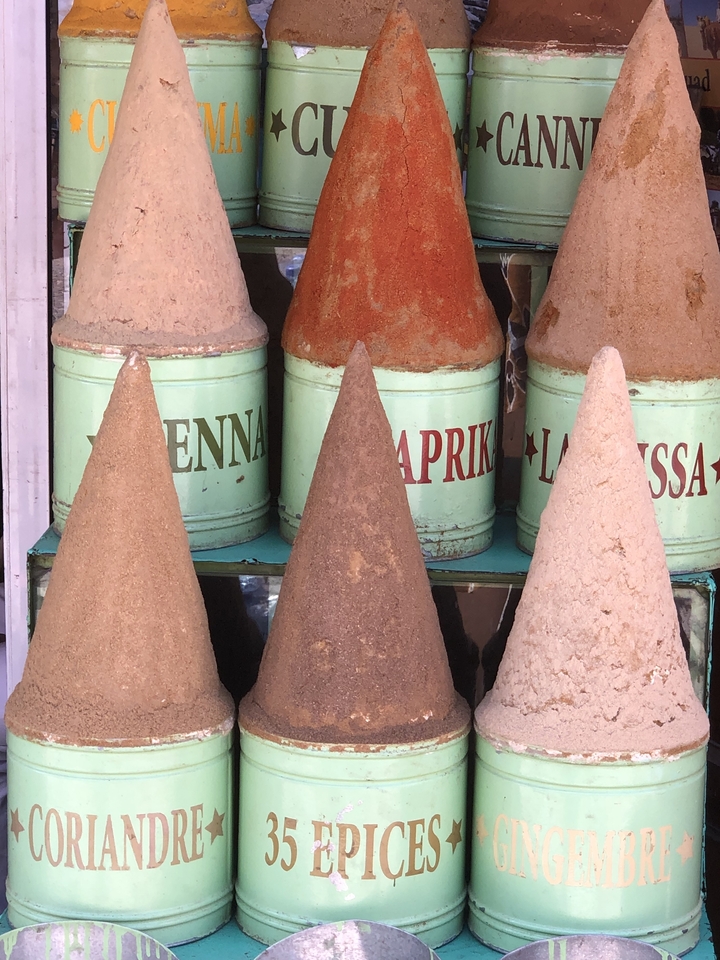 Épices en forme de cônes avec étiquettes disposées sur des bocaux.