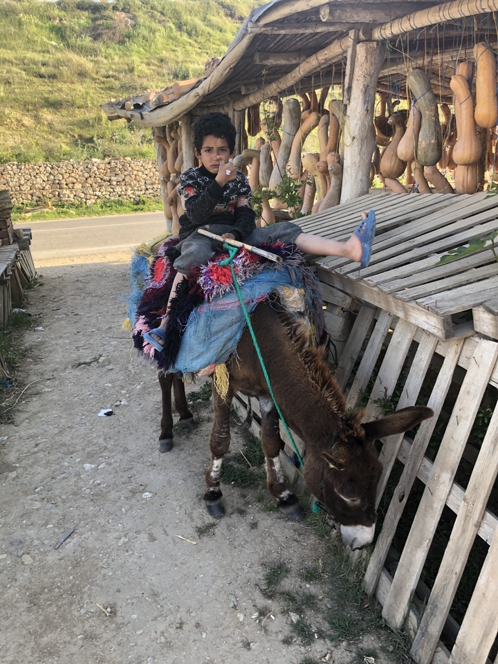 Enfant montant un âne avec des couvertures de selle colorées.