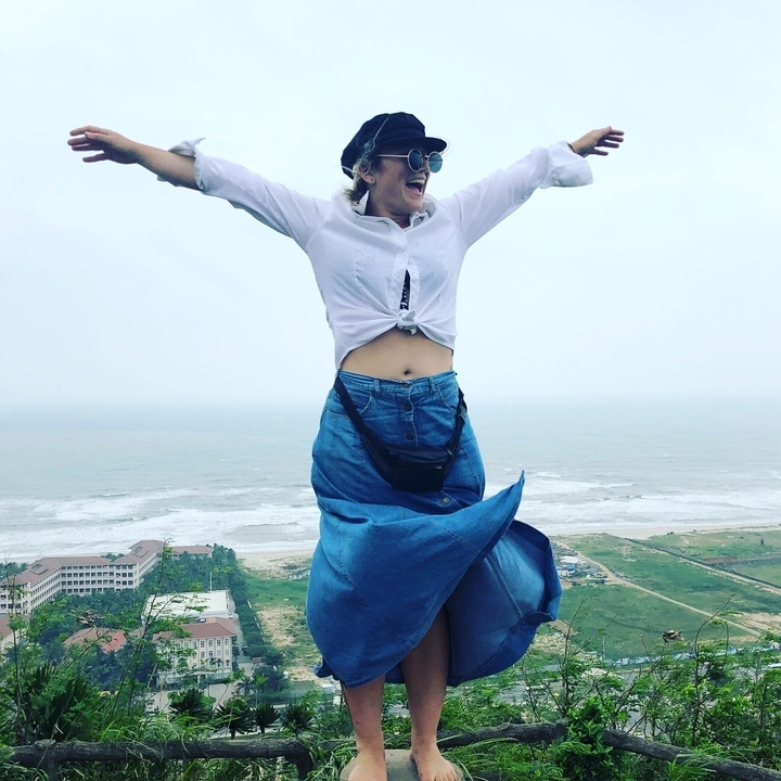 Personne sautant joyeusement avec une vue côtière.