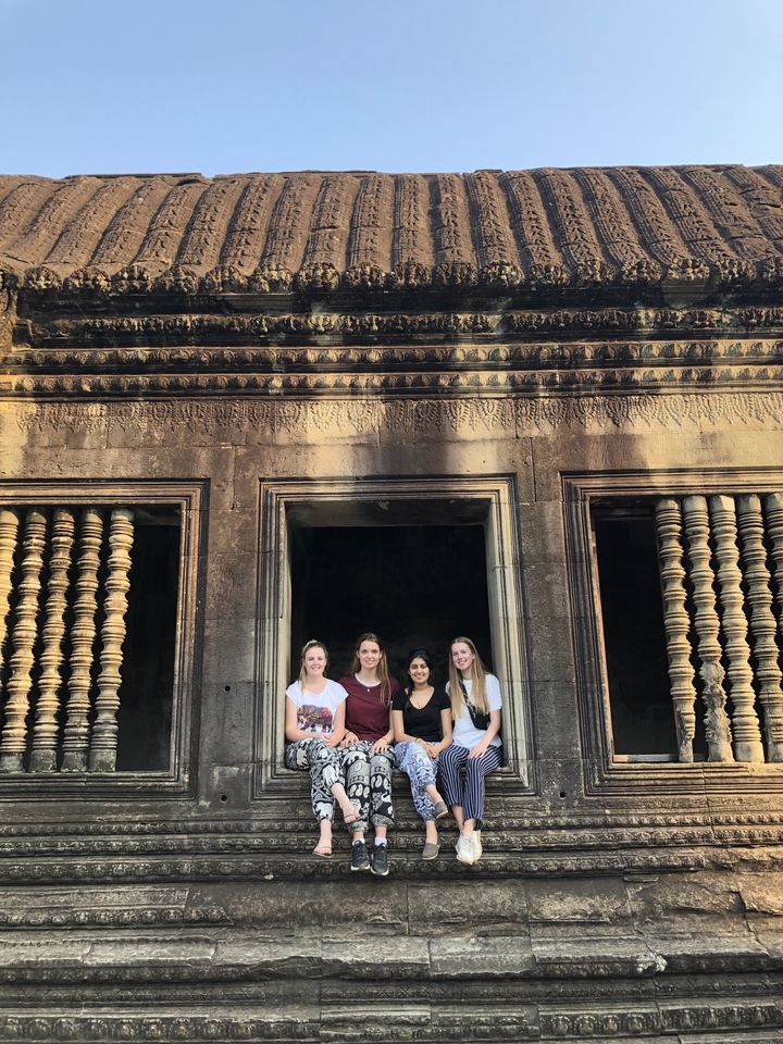 Quatre femmes posant devant un temple ancien.