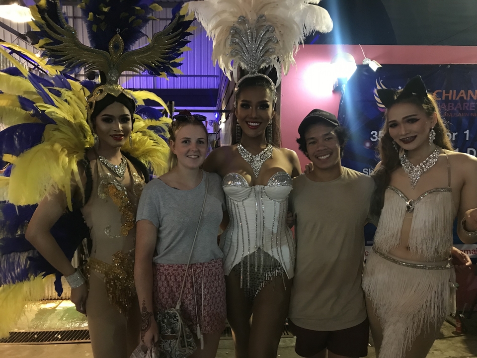 Des personnes qui prennent la pose avec des artistes en costumes élaborés.