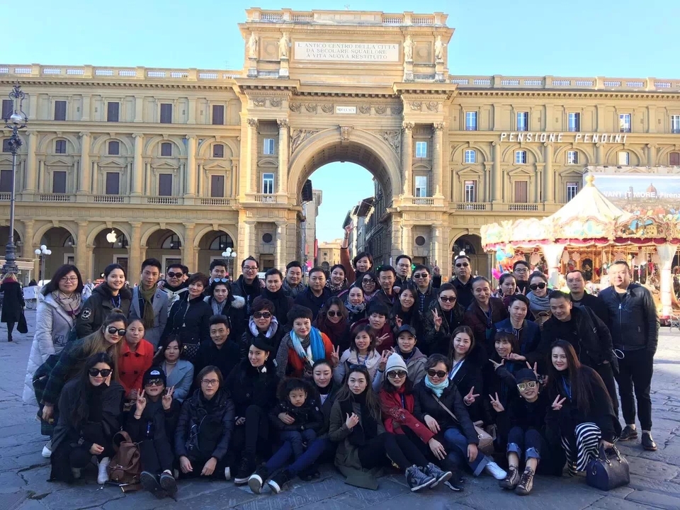 Grand groupe posant devant un bâtiment historique.