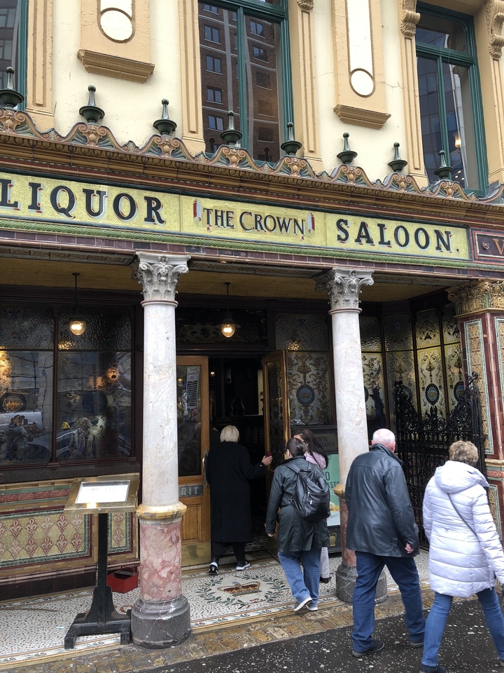 Entrée d'un pub historique avec des personnes qui entrent.