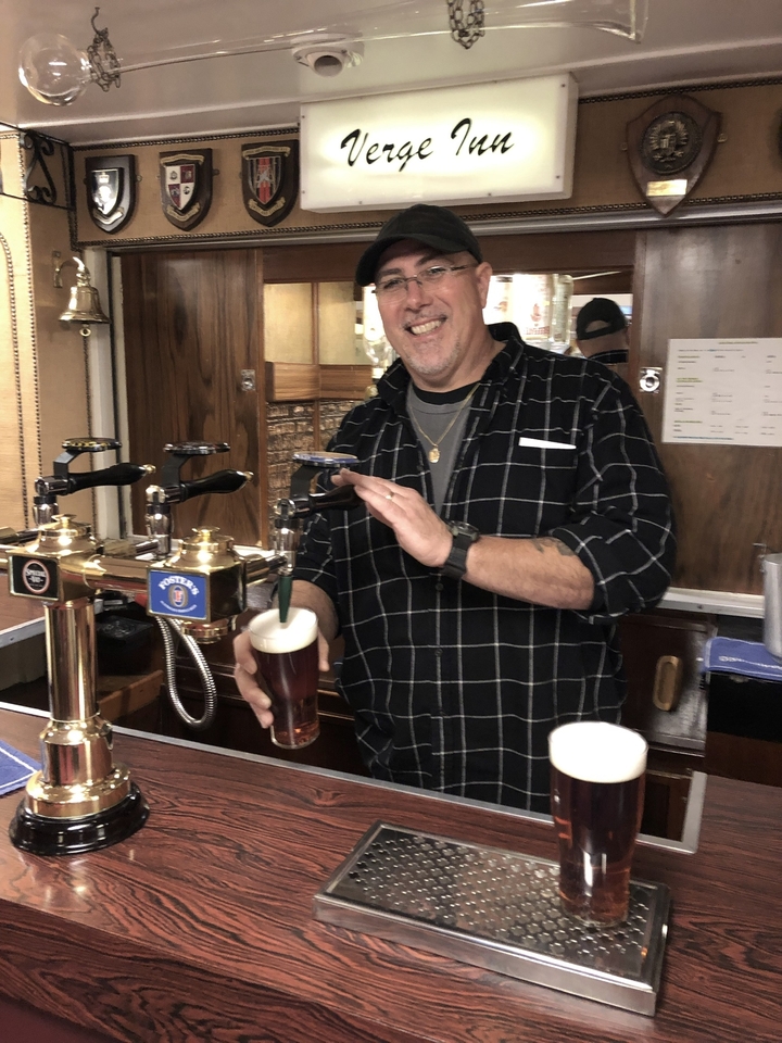 Homme versant une pinte dans un pub.