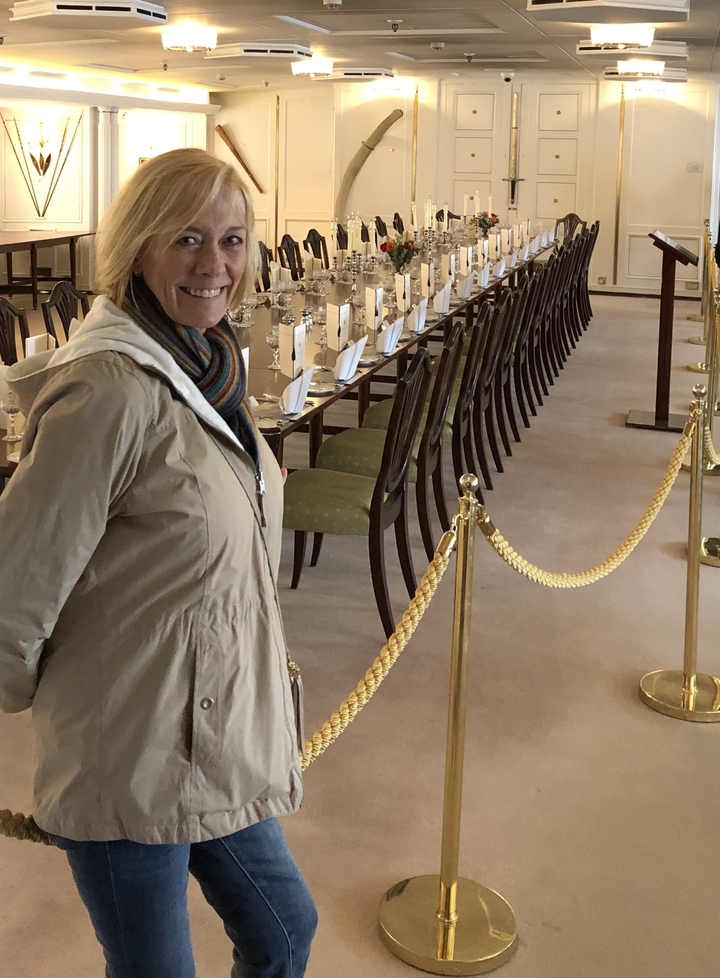 Woman standing in an elaborate dining room.