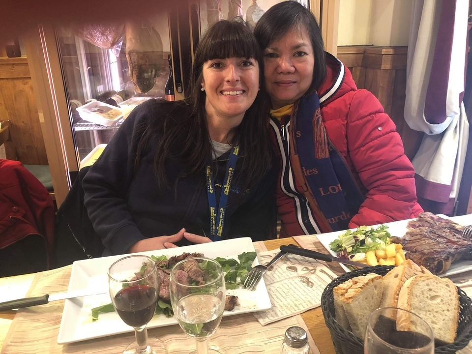 Deux femmes assises à une table avec des plats de nourriture.