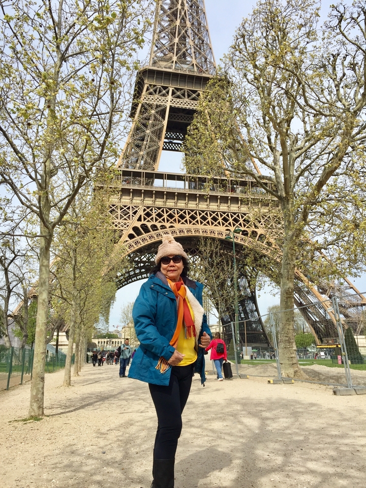 Femme qui pose devant la tour Eiffel.