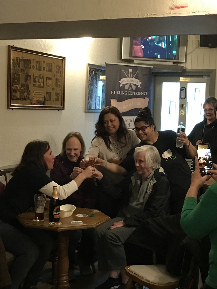 Groupe portant un toast dans une ambiance de pub animée.