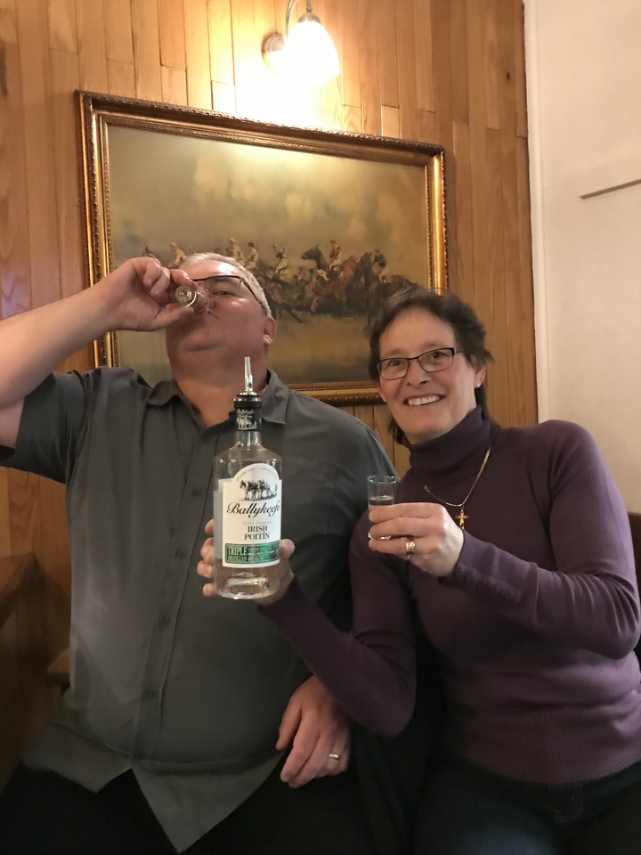 Un couple buvant des verres de Poitín irlandais dans un pub.