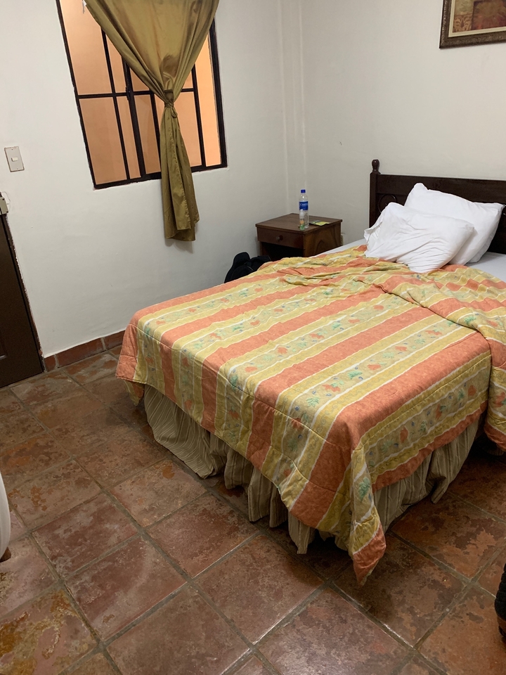 Lit défait dans une chambre simple.