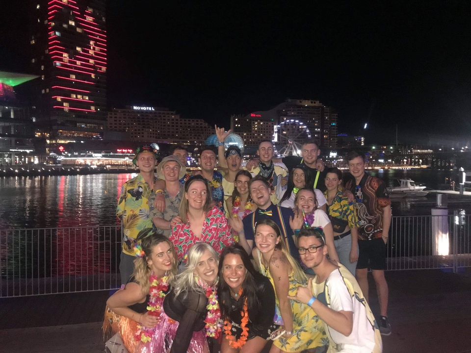 Groupe de personnes profitant d'une soirée au bord de l'eau avec les lumières de la ville.